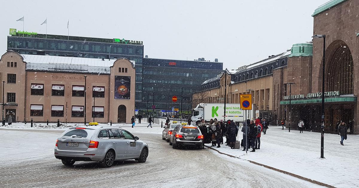 Takseja Helsingin rautatieaseman edessä, ihmisiä menossa takseihin (Kuva: Shutterstock, Jay Lee)