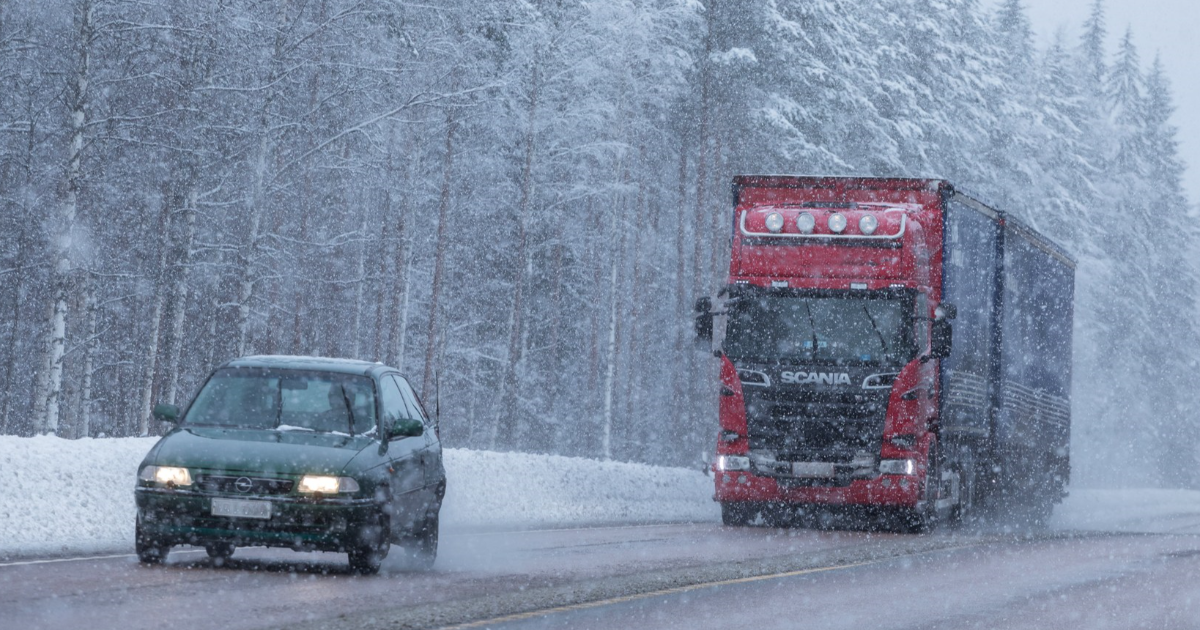 A car aand a truck on a road, winter, snowing (Photo: Juha Tuomi)