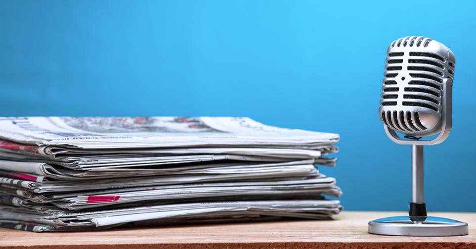 Sanomalehtiä ja mikrofoni. Kuva: Shutterstock