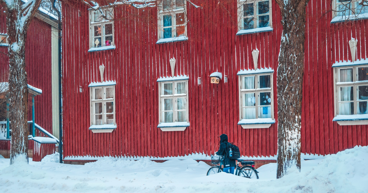 Pyöräilijä taluttaa pyörää Helsingissä talvella. (Kuva: Shutterstock)