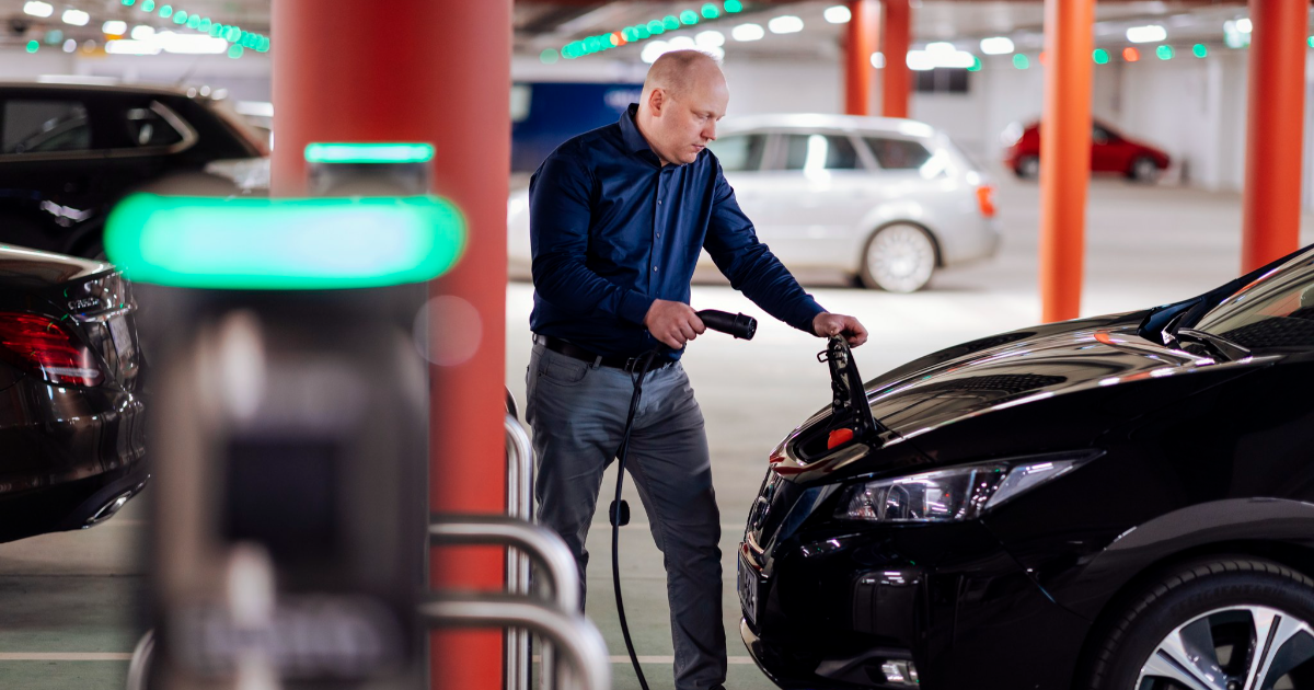 A man charging an electric car (Phtoto: Mika Pakarinen, Keksi Agency)
