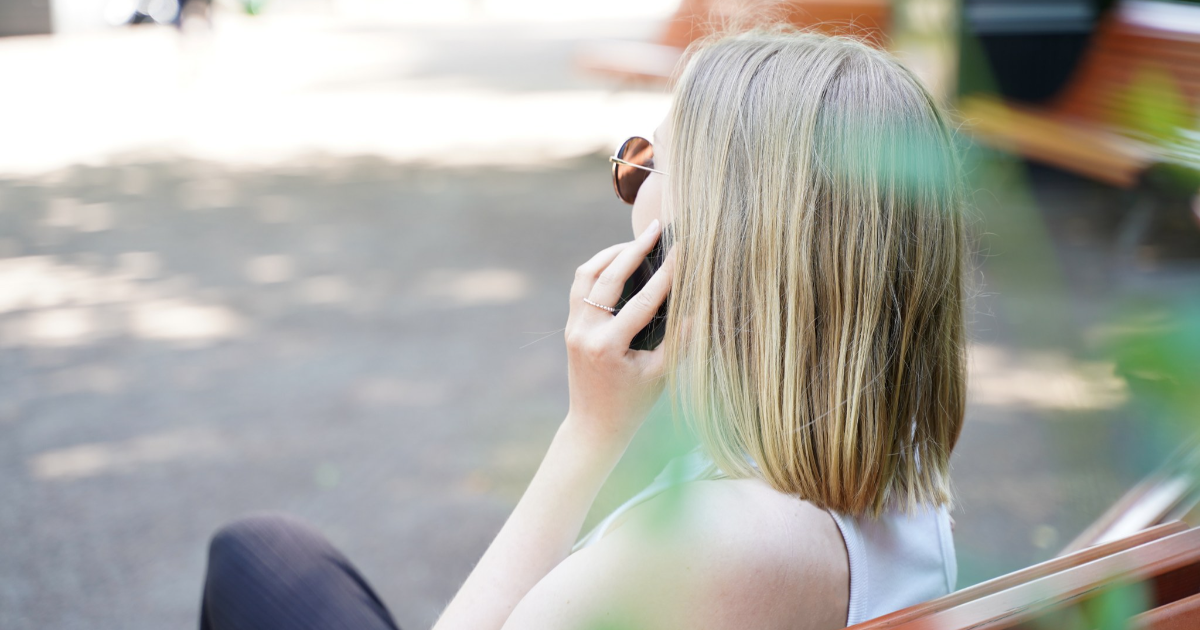 En kvinna som talar på mobiltelefonen i Esplanade Park, sommar (Foto: KM)