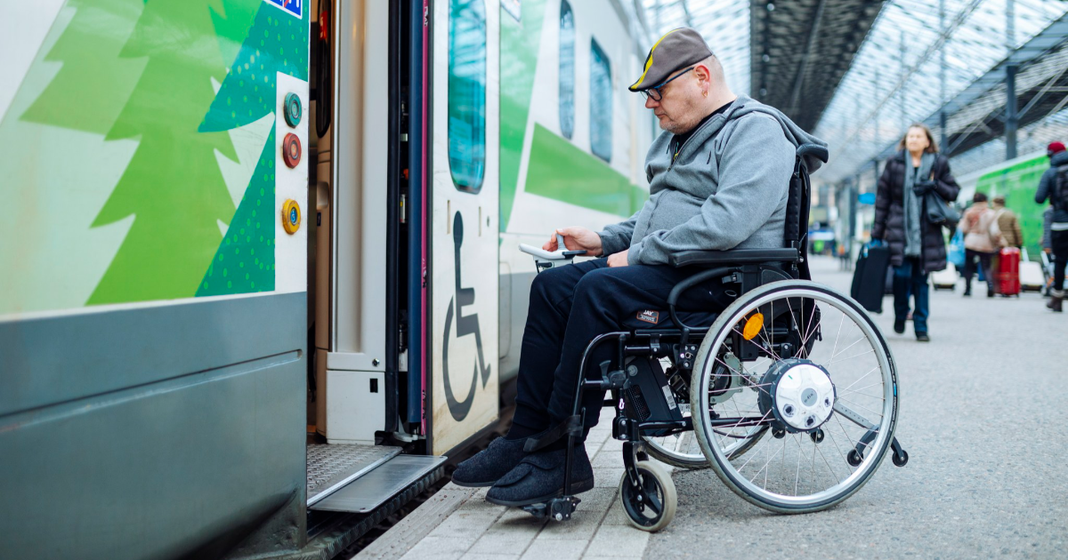 Pyörätuolia käyttävä mies nousee junaan. (Kuva: Mika Pakarinen, Keksi / LVM)