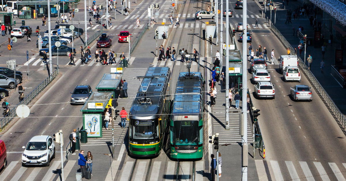 Spårvagnar och bilar framför Helsingfors järnvägsstationen (Foto: Shutterstock/Milkovasa)