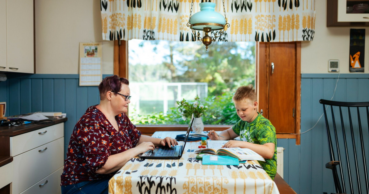 Nainen työskentelee ja lapsi tekee läksyjä kotona. (Mika Pakarinen, Keksi / LVM)