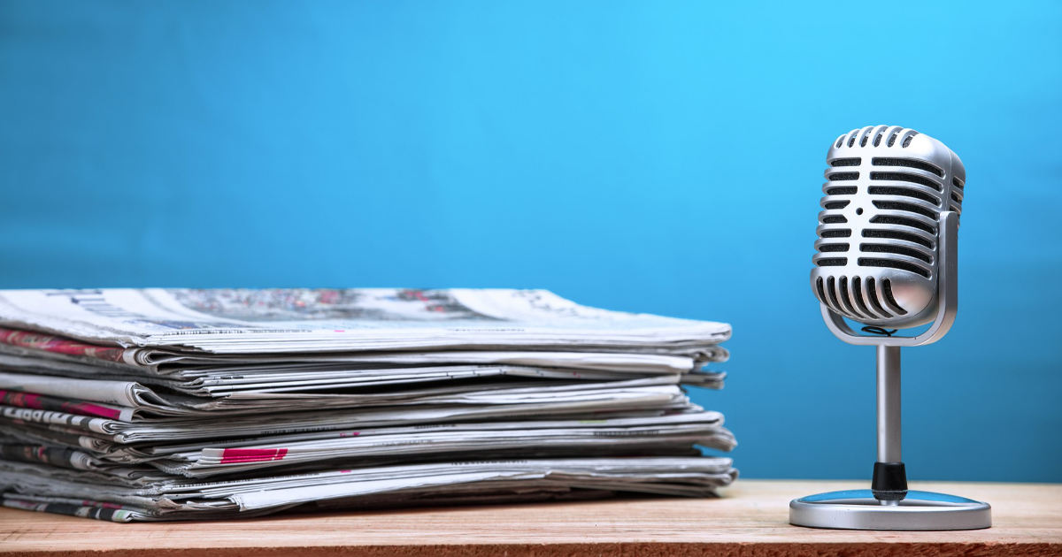 Sanomalehtiä ja mikrofoni (Kuva: Shutterstock)